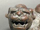 a small statue of a lion with a smile on it ' s face