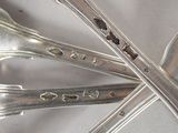 several silver spoons and spoon spoons are arranged on a white surface