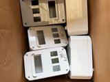 many electronic devices in a cardboard box on the floor