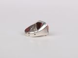 a silver ring with a red stone in it