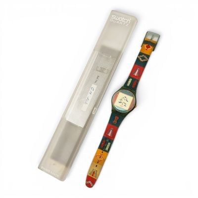 a watch that is sitting next to a pen