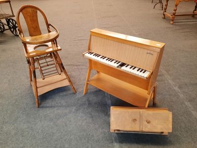 une chaise haute et un piano dans une pièce