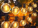 une guirlande d'ampoules suspendue à un arbre devant une cabane