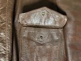 a close up of a brown leather jacket with a pocket