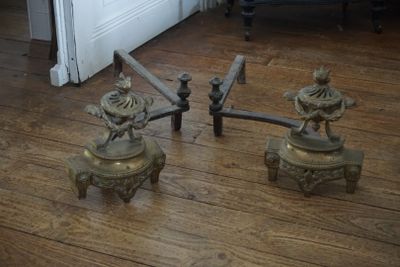 une paire de bougies anciennes en laiton posées sur un parquet