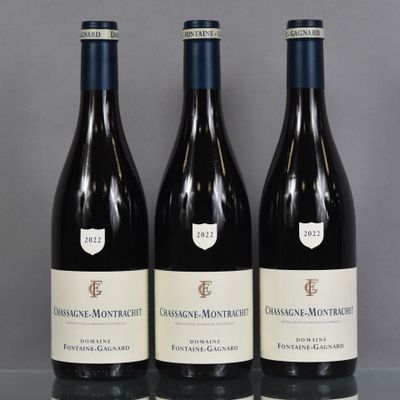 three bottles of red wine sit on a glass table