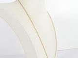 a white mannequin torso with a gold chain on it