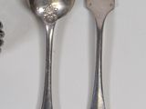 a spoon, fork, and spoon rest on a table