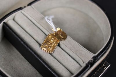 a gold medal in a case on a black surface