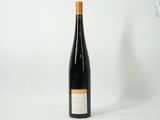the bottle of wine is sitting on a white surface