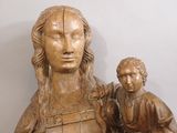 a wooden statue of a woman holding a child
