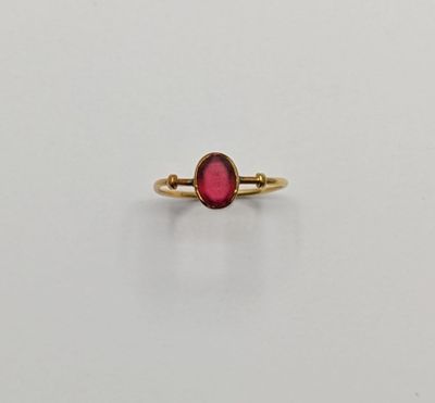 a gold ring with a red stone in the middle
