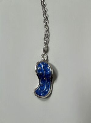 a silver necklace with a blue face on a chain