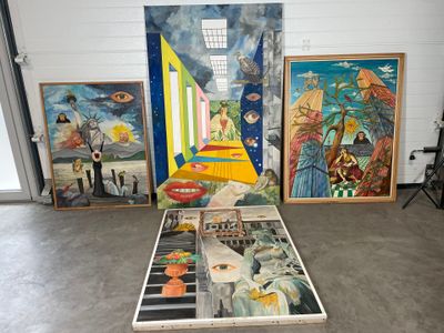de nombreux tableaux posés par terre dans une pièce