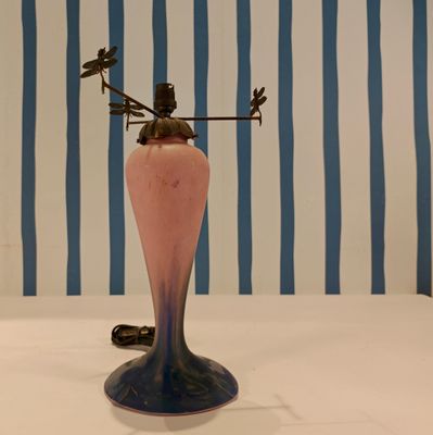 a pink vase with a weather vane on top of it