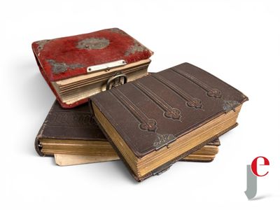several old books are stacked on top of each other on a white surface