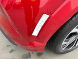 a close up of a red car with a sticker on it ' s bumper