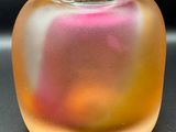 un vase en verre contenant un liquide rose et jaune