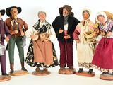 seven figurines of people dressed in traditional clothing