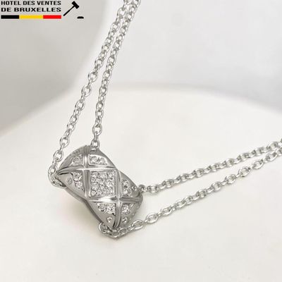 collier avec un pendentif en diamant sur une chaîne, posé sur un fond blanc