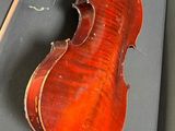 an old violin sitting on top of a table next to a bow