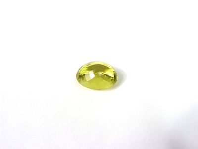 un gros plan d'une pierre précieuse jaune sur une surface blanche