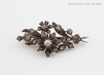 an image of a silver broochle with flowers and leaves