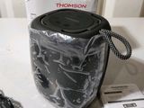a black speaker sitting on top of a table next to a charger