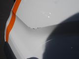 a white car with an orange stripe on the hood