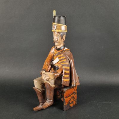 a wooden statue of a soldier sitting on a chair