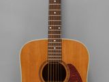 an image of a wooden guitar on a gray background