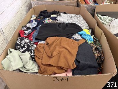 une boîte en carton remplie de vêtements dans une pièce