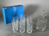 four glasses and a decanter in front of a blue box