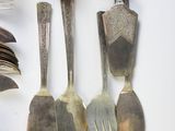 several spoons, forks, and spoon rest on a white surface