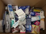 a cardboard box filled with toothbrushes, toothpaste, toothpaste, toothpaste, toothpaste, toothpaste, and
