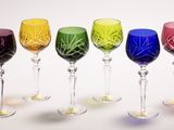 cinq verres à vin alignés sur une surface blanche