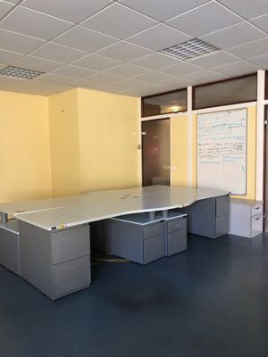 un bureau vide avec deux bureaux et un tableau blanc accroché au mur