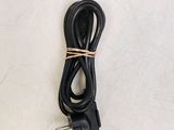 a close up of a black power cord on a white surface