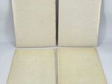 two open books sitting on top of each other on a white surface
