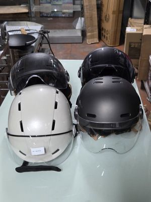 Plusieurs casques sont alignés sur une table dans un magasin
