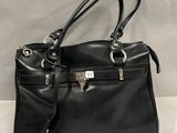 un sac à main en cuir noir posé sur une table blanche, sur fond blanc
