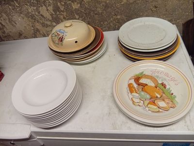 many plates and bowls on the counter top of the refrigerator