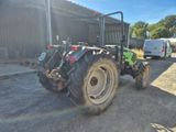 un tracteur garé sur un terrain en terre battue