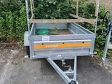 a small trailer with a cage on the back of it