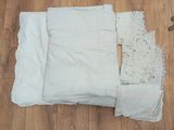 un tas de draps blancs et un sous-vêtement posés sur un plancher en bois