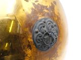 a gold vase with a black knob on it