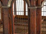 a wooden bird cage with a clock on top of it