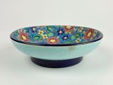 blue and green bowl with a floral design on the rim