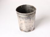 a silver cup that is sitting on a white surface