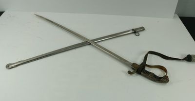 deux épées et une pince posées sur une table blanche